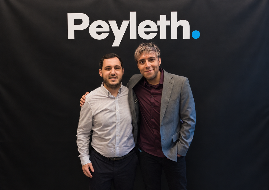 Santiago Marín y Álvaro Martínez, cofundadores de Peyleth, delante del logo Peyleth.